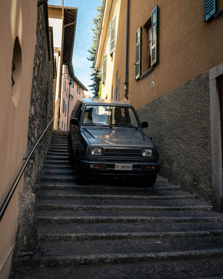 in the village of Torno, on the shores of Lake Como, this image captures a surreal scene where a small car finds itself stranded midway down a centuries-old stone stairway
